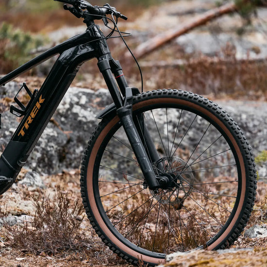 Trek Rail+ 8 Gen 5 musta sähkömaastopyörä etuhaarukalla metsässä