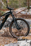 Trek Rail+ 8 Gen 5 musta sähkömaastopyörä etuhaarukalla metsässä