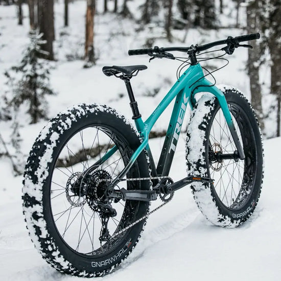 Trek Farley lumisessa maastossa takaa sivusta